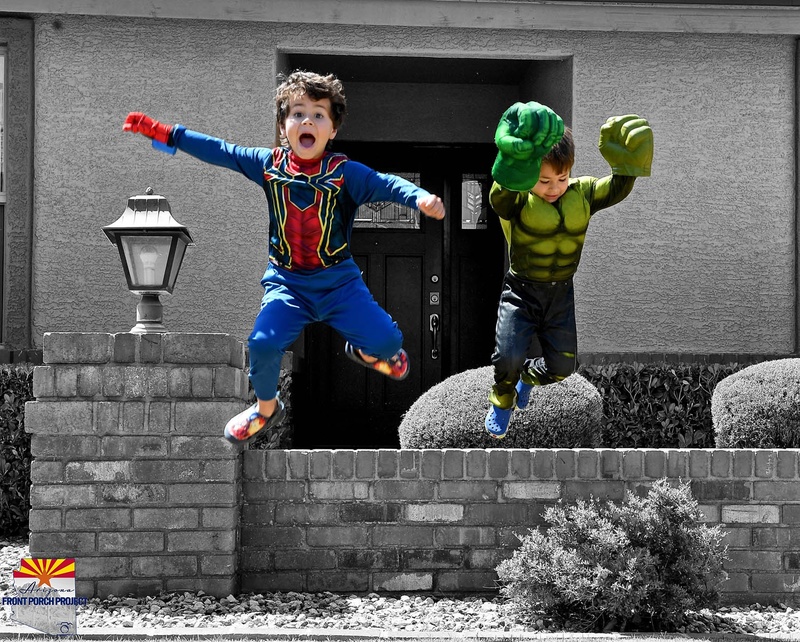 Two children in costumes jumping. 