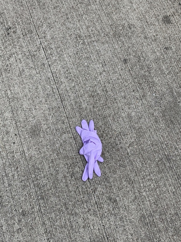 This is a picture taken of a discarded medical glove on a sidewalk. 