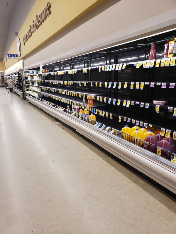 Image of a mostly empty shelf in a grocery store.