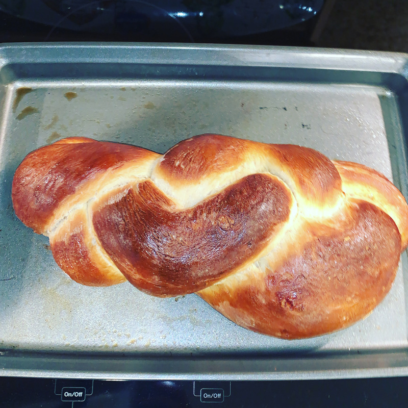 This is a picture of freshly baked Challah bread resting in a pan. 