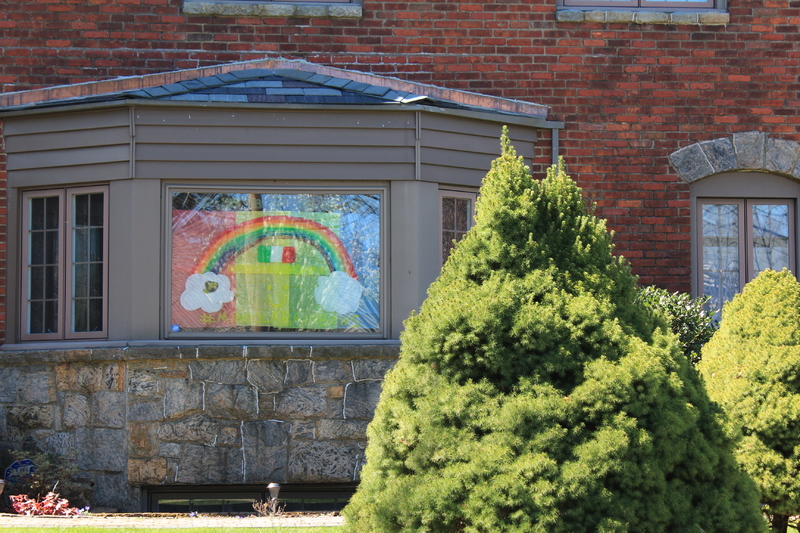 A rainbow drawn on a home window with an Italian flag in the middle and #mineolaranbow written below it.
