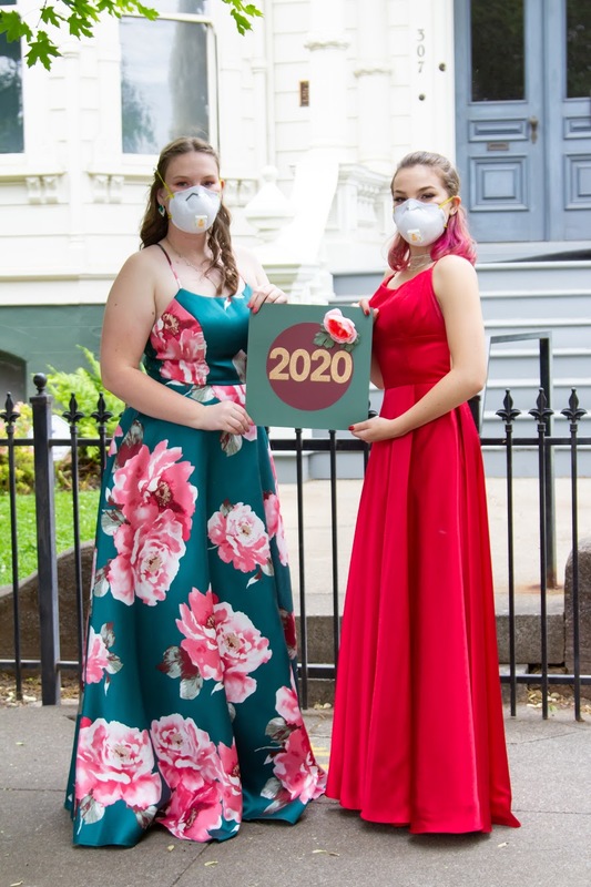 Image of two girls dressed for prom, wearing masks.