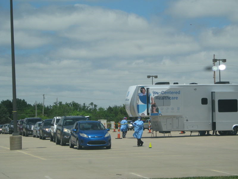 Photo of several cars in line for a drive-thru COVID testing site.