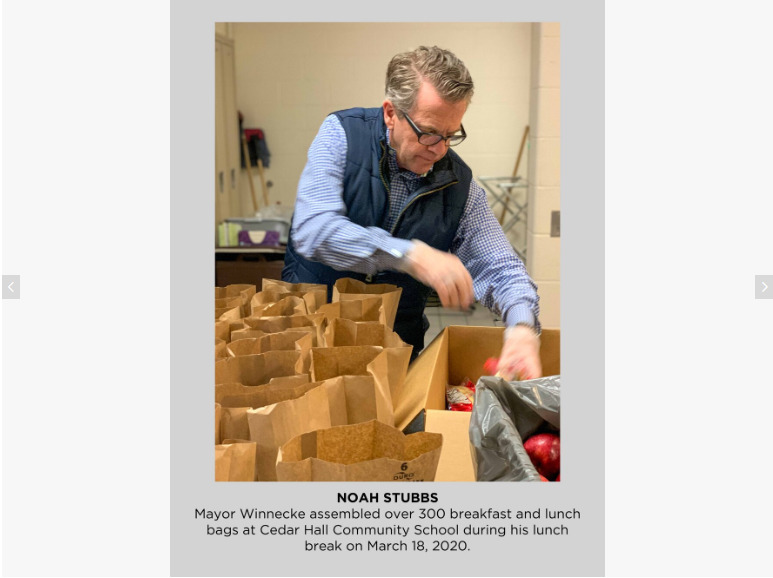 Photo of a man placing food into brown paper bags. 