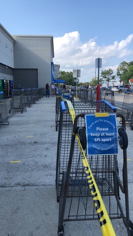This is a picture taken of a line of shopping carts that have been turned on their sides, connected with tape, and made into an area to wait in line to enter a store. 