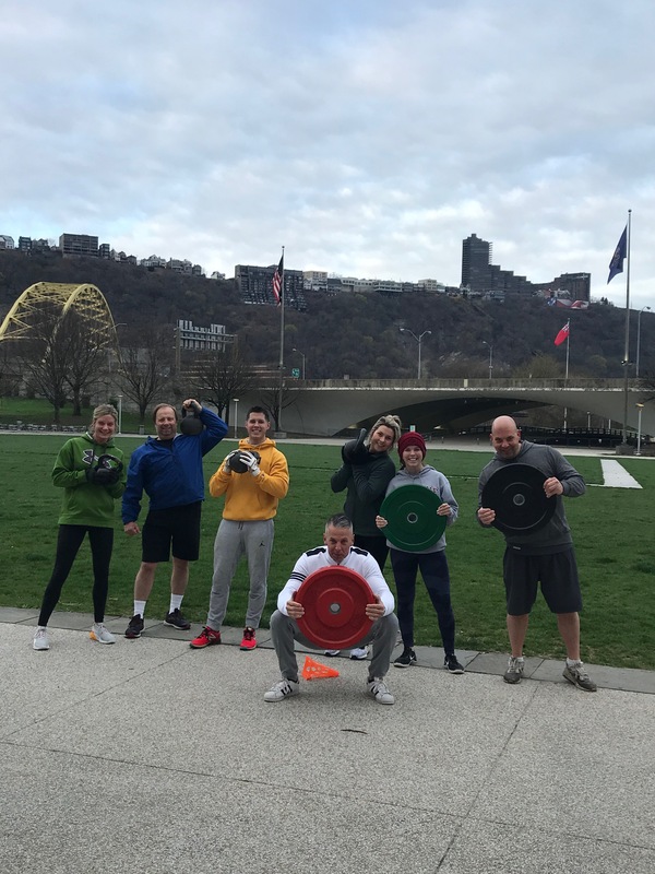 Seven people holding weights at Point Park.