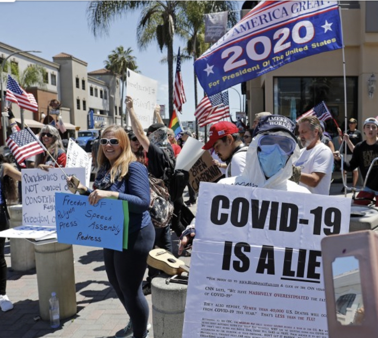 A photo of people protesting the COVID-19 pandemic and COVID-19 restrictions.