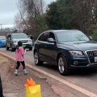 Cars driving by wishing a child a happy birthday.