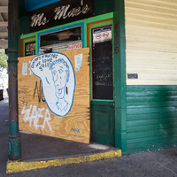 A man waiting for a bus in front of Ms. Mae's Bar in New Orleans. 