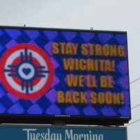 A billboard that reads "Stay strong Wichita! We'll be back soon!"