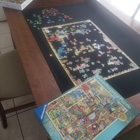 A table that has a puzzle being put together in progress. 