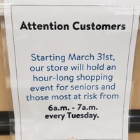 A sign reading "Attention Customers. Starting March 31st, our store will hold an hour-long shopping event for seniors and those most at risk from 6 AM to 7 AM every Tuesday".