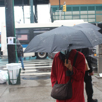 A person with a mask on holding an umbrella. 
