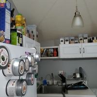 Kitchen cabinets with organized bins above.