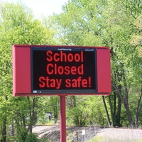 A digital sign reading "School Closed. Stay Safe!".