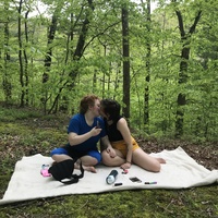 couple kissing on a picnic blanket in the woods