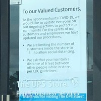 Image of a sign on the door of the UPS store which reads to our valued customers, as the nation confronts Covid-19, we would like to update everyone on our ongoing actions to protect our community. For the safety of our customers and employees we have updated our procedures. We are limiting the number of customers inside the store to three to allow social distancing. We ask that you maintain a distance of six feet between other people while in store, per CDC guidelines.
