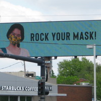 Billboard with a person wearing a facemask with text, "ROCK YOUR MASK!"