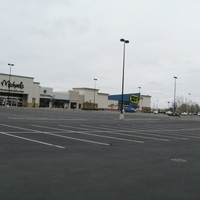 Image of an empty parking lot outside of a Best Buy and Michael's.