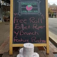 Image of a local restaurant chalkboard sign with a stack of toilet paper in front of it which reads free roll of toilet paper with brunch.