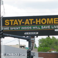Billboard that reads stay inside, time spent at home will save lives.