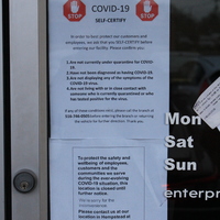 Two signs from Enterprise Car Rental. The first sign says "Stop. COVID-19 self certify. In order to best protect our customers and employees, we ask that you SELF-CERTIFY before entering our facility. Please confirm you:  1. Are not currently under quarantine for COVID-19. 2. Have not been diagnosed as having COVID-19. 3. Are not displaying any of the symptoms of the COVID-19 virus. 4. Are not living with or in close contact with someone who is currently quarantined or who has tested positive for the virus. If any of these conditions exist, please call the branch at 516-746-0505 before entering the branch or returning the vehicle for further direction. Thank you."
The second sign says "To protect the safety and wellbeing of employees, customers and the communities we serve during the ever-evolving COVID-19 situation, this location is closed until further notice. We're sorry for the inconvenience. Please contact us at our location in Hempstead at 516-481-6363. Enterprise" 