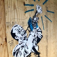 Street art of a man playing an instrument. 