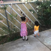 Two kids by a fence. 