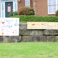 Two homemade signs in a front yard. 