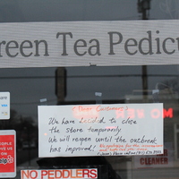 A handwritten sign at Green Tea Pedicure informing its customers that the salon will be closed temporarily; and will reopen once the outbreak improves.  