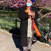 An old woman with her mask on in a park. 