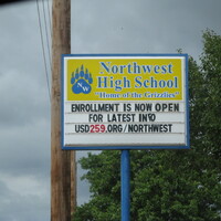A high school sign reading "Enrollment is Now Open. For Latest Info USD259.org/northwest".