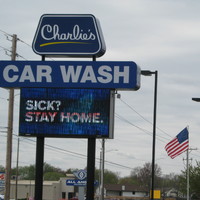 Image of a car wash business sign which reads Sick? Stay home.