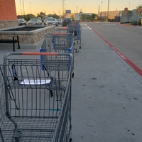 A line of shopping carts in a parking lot. 