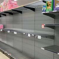 This is a picture taken of mostly empty shelves at a grocery store. 