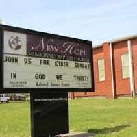 Photo of a sign outside New Hope Missionary Baptist Church reading "join us for cyber Sunday. In God we trust"
