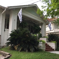 Two white flags hung on the front porch of a house that say "We (heart) doctors" and "We (heart) nurses."