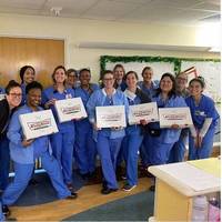 A photo of a group of healthcare workers holding Krispy Kreme donut boxes.