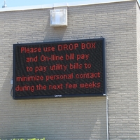 Digital sign reading "Please use Drop Box and on-line bill pay to pay utility bills to minimize personal contact during the next few weeks".