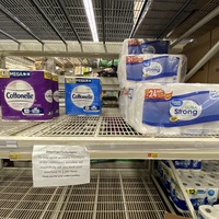 Photo of an almost empty toilet paper aisle at a store.