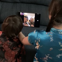 Back of two children FaceTiming with an older couple during Chinese New Year.