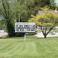 A sign reading "On Line Sunday 9 AM chandlercpchurch.com, God Bless, Stay Safe".